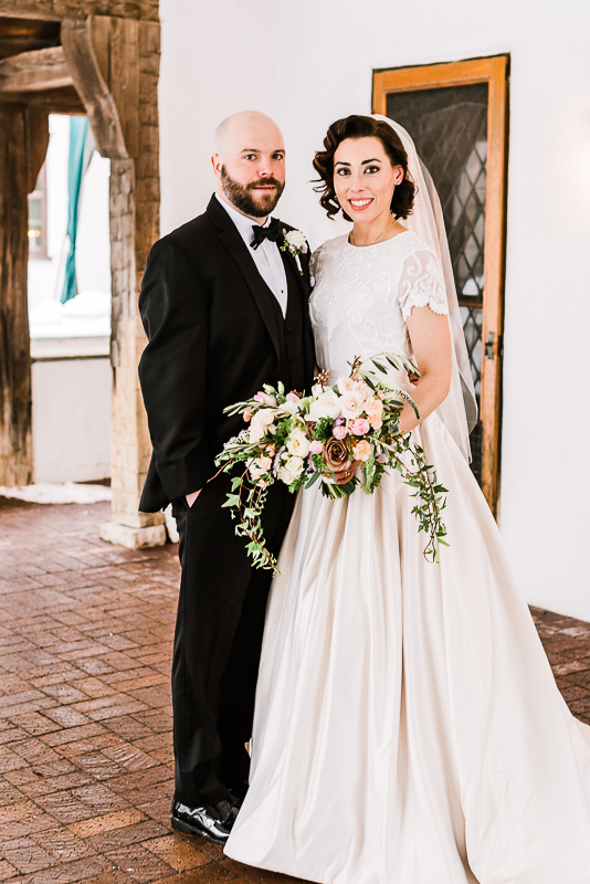 Bride and groom in tux holding soft cream and lavender colored roses on brick pavers facing camera smiling in traditional pose  Addison Oaks Buhl Estate by Stephanie Anne Photography