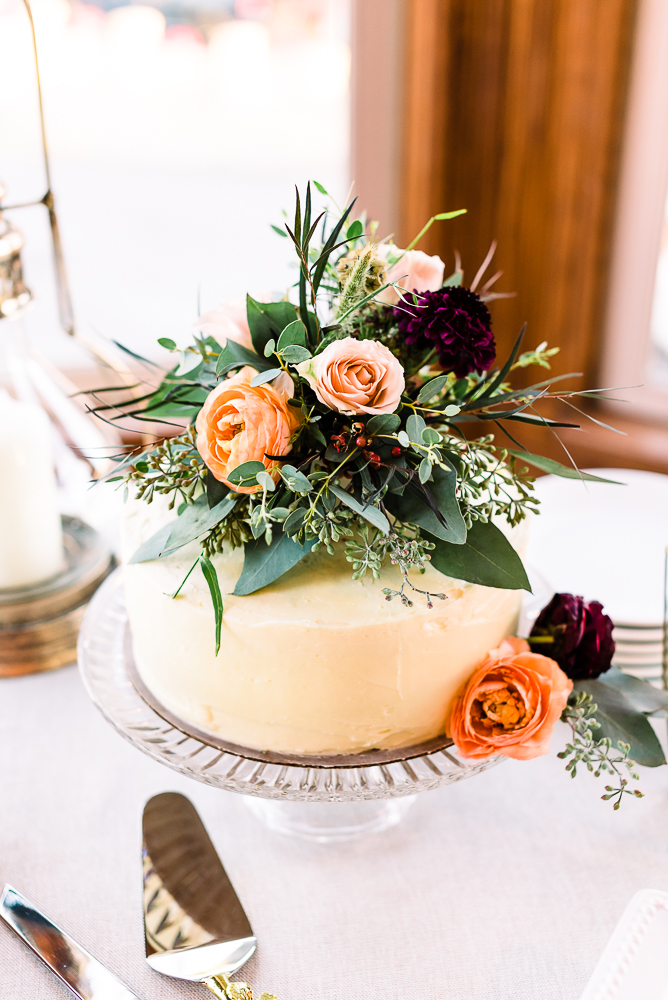 Small cake with peach and burgundy flowers on top by Grand Rapids Wedding photographer Stephanie Anne